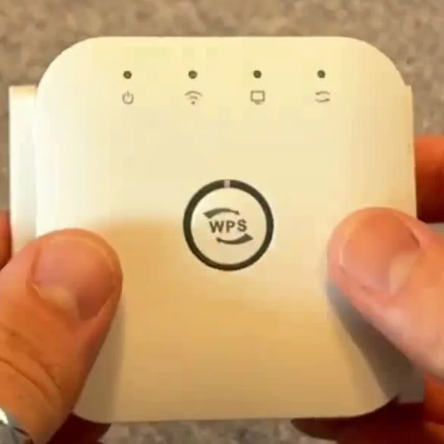 NetBoost Pro extender held during setup with its WPS button visible